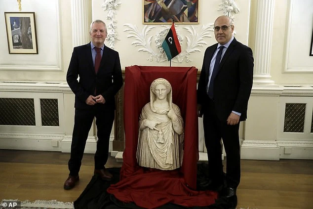 Mohamed Elkoni (r), the charge d'affaires of the Embassy of Libya, stands next to the statue with Peter John Higgs from the British Museum (l)