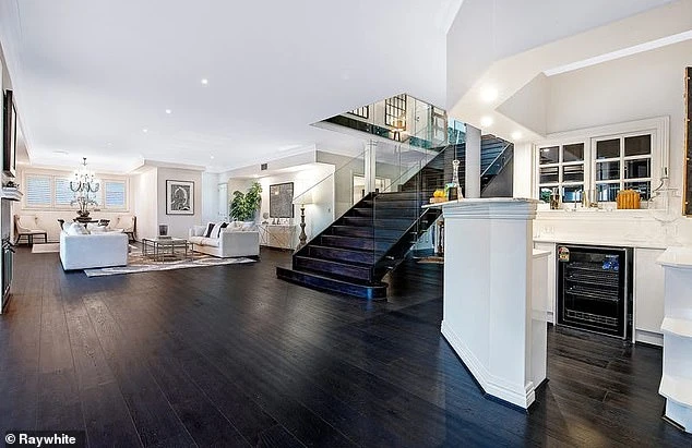 Home, sweet home: the open plan living space has black parquet floors and a staircase leading to the second floor