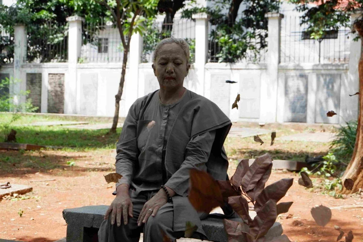 Empty future: Arahmaiani, face and head covered in clay, performs 