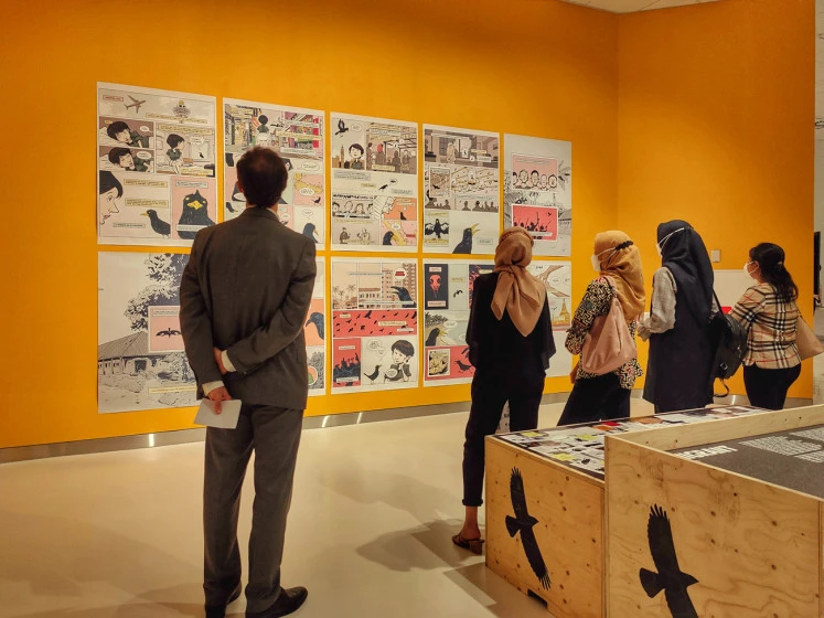 Picture perfect: Exhibit visitors view images of Javan mynahs in cages.  (JP/Sylviana Hamdani)